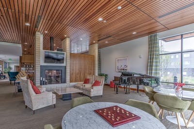 Bright common area with seating and a piano