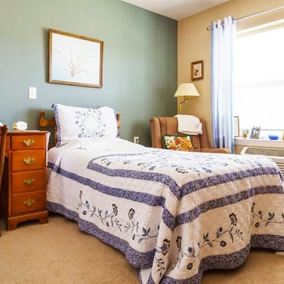 Cozy resident bedroom with quilt and chair
