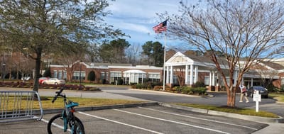 Facility exterior with flag and landscaped front entrance