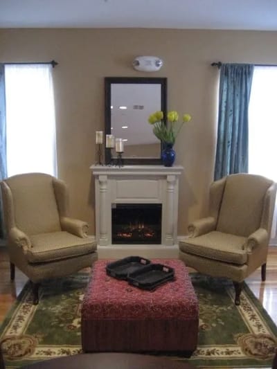 Cozy interior sitting area with two chairs and a fireplace