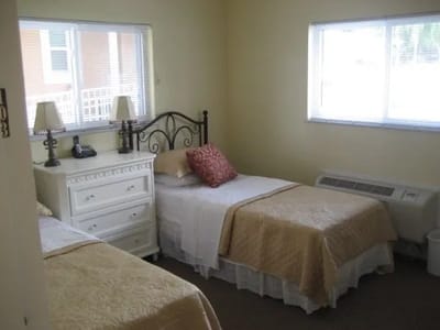 A guest room with two beds and a dresser