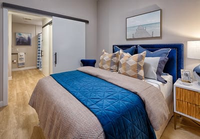 A well-decorated private resident room with a bed and artwork