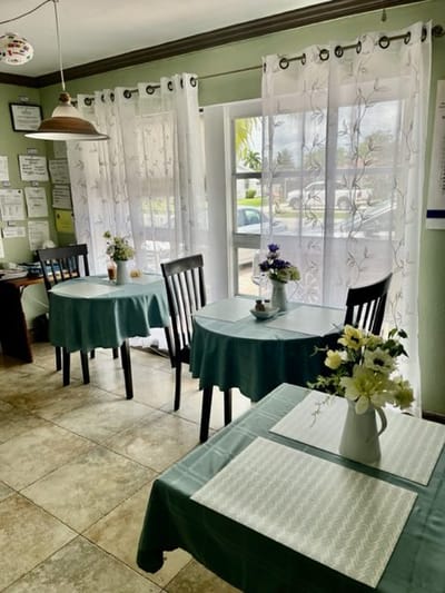 Cozy dining area with tables and floral centerpieces at Blue Ribbon Care