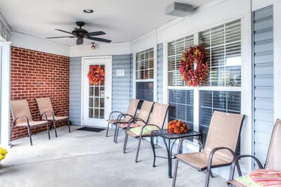 Seating area with seasonal wreaths on a porch