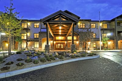 Exterior view of a senior living facility entrance at dusk