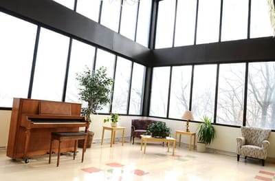 Bright common area with large windows and a piano