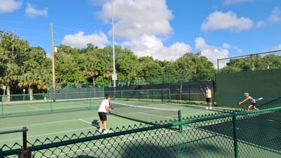 Residents playing tennis on an outdoor court
