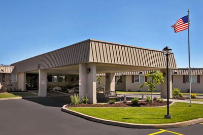 Exterior view of a senior living facility with an American flag