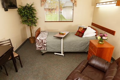 A cozy resident room with a bed and small dining area