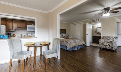 A cozy resident room with a bed and seating area