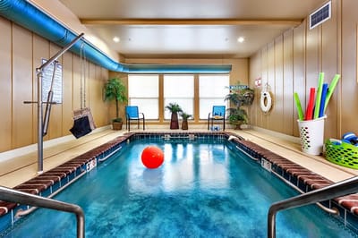 Indoor pool area with exercise equipment and floating toys