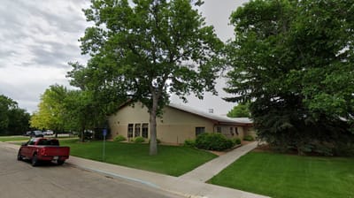 Exterior view of a senior living facility surrounded by trees