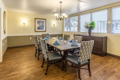 Bright dining room with large windows and tables set