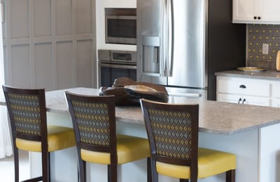 A modern kitchen area with stools and appliances