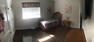 Private resident room with floral bedding and sunny window