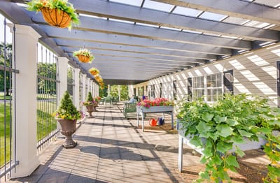 Covered outdoor seating area with flowers and plants
