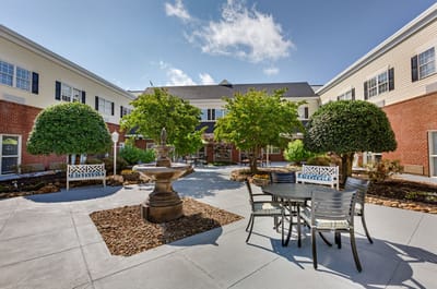A serene outdoor courtyard with seating and trees