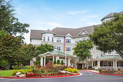 Exterior view of a senior living facility with gardens