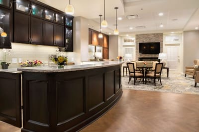 Bright common area with seating and a kitchen.