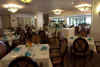 Dining room with neatly set tables and flowers