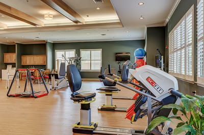 Fitness room with exercise equipment and large windows