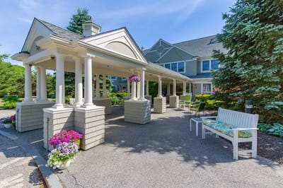Covered entrance area with flowers and seating