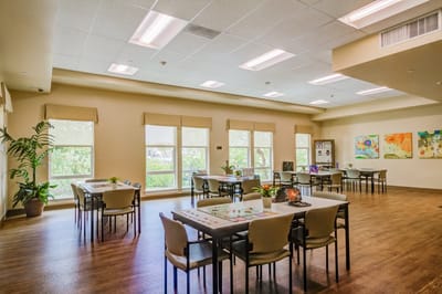 Bright interior common area with tables and artwork