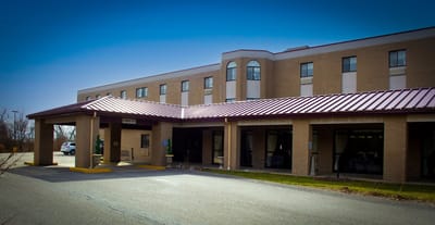 Exterior view of the facility with entrance and parking area
