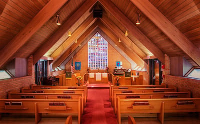 Interior view of a chapel with wooden beams and seating