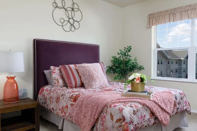 Cozy resident bedroom with floral bedding and natural light
