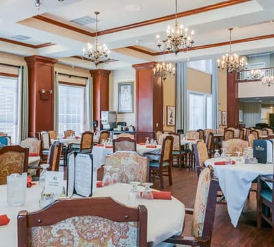 Elegant dining area with chandeliers and tables set for meals