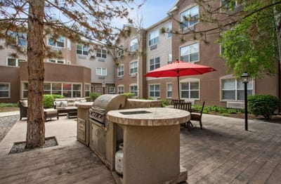 Outdoor grilling area with seating and umbrellas