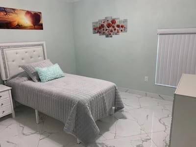 Brightly decorated private resident room with bed and artwork