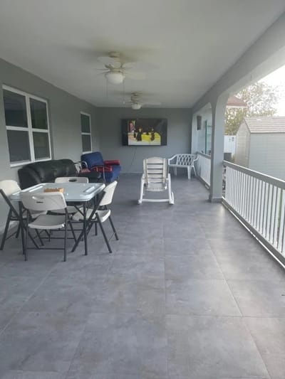 Covered outdoor patio area with seating and a TV