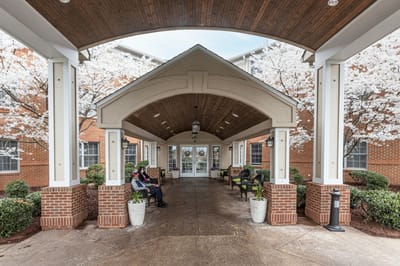 Residents relaxing in a covered outdoor area with flowers