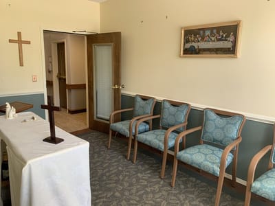 A quiet chapel area with chairs and a cross