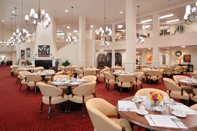 Dining room with elegantly set tables and chandeliers