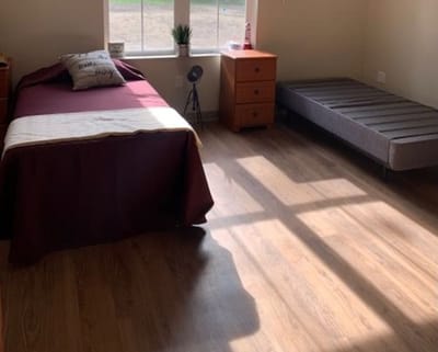 A well-furnished private room with a bed and dresser