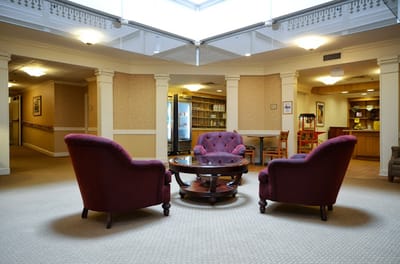 Cozy common area with purple chairs and a coffee table