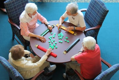 Residents engaged in a game around a table