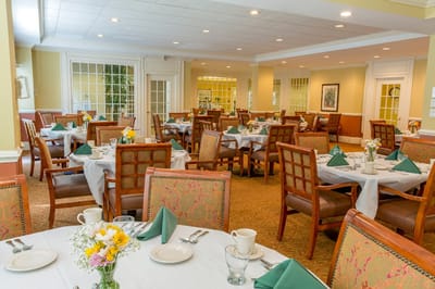 Bright dining area set for a meal with floral centerpieces