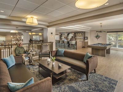 Residents enjoying a common area with seating and a pool table