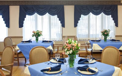 Well-set dining area with blue tablecloths and flower arrangements