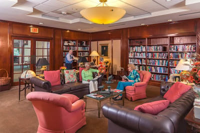 Residents reading in a cozy library-style common area