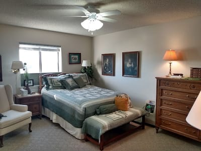 Cozy bedroom with a bed, dresser, and armchair