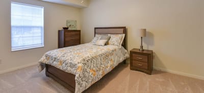 A cozy bedroom featuring a bed, nightstands, and a window.