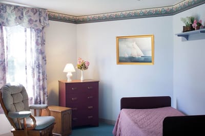 Private resident room with a bed and chair