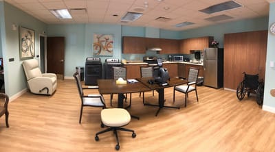 A common area in a nursing home with seating and cabinets
