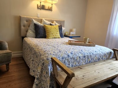 Cozy guest room with floral bedding and a tray on the bed