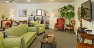 A cozy common area with seating and bookshelf